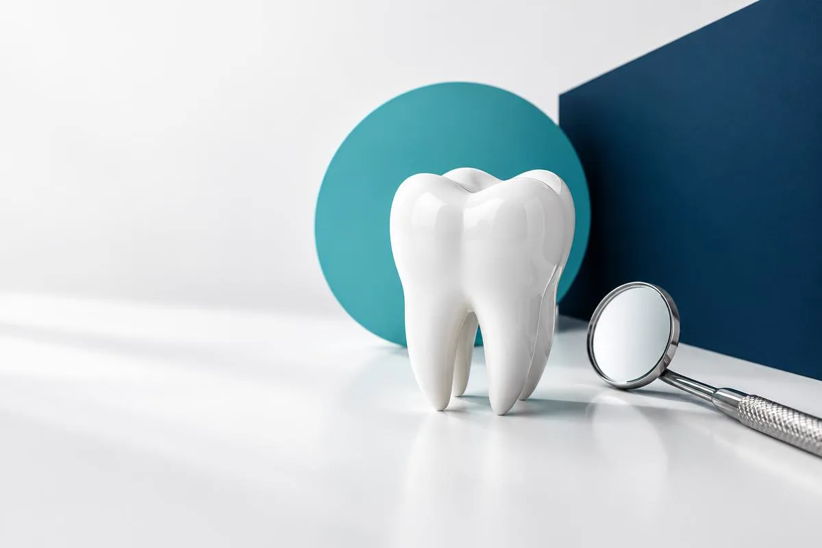Dent en céramique et miroir dentaire dans une composition marine et turquoise